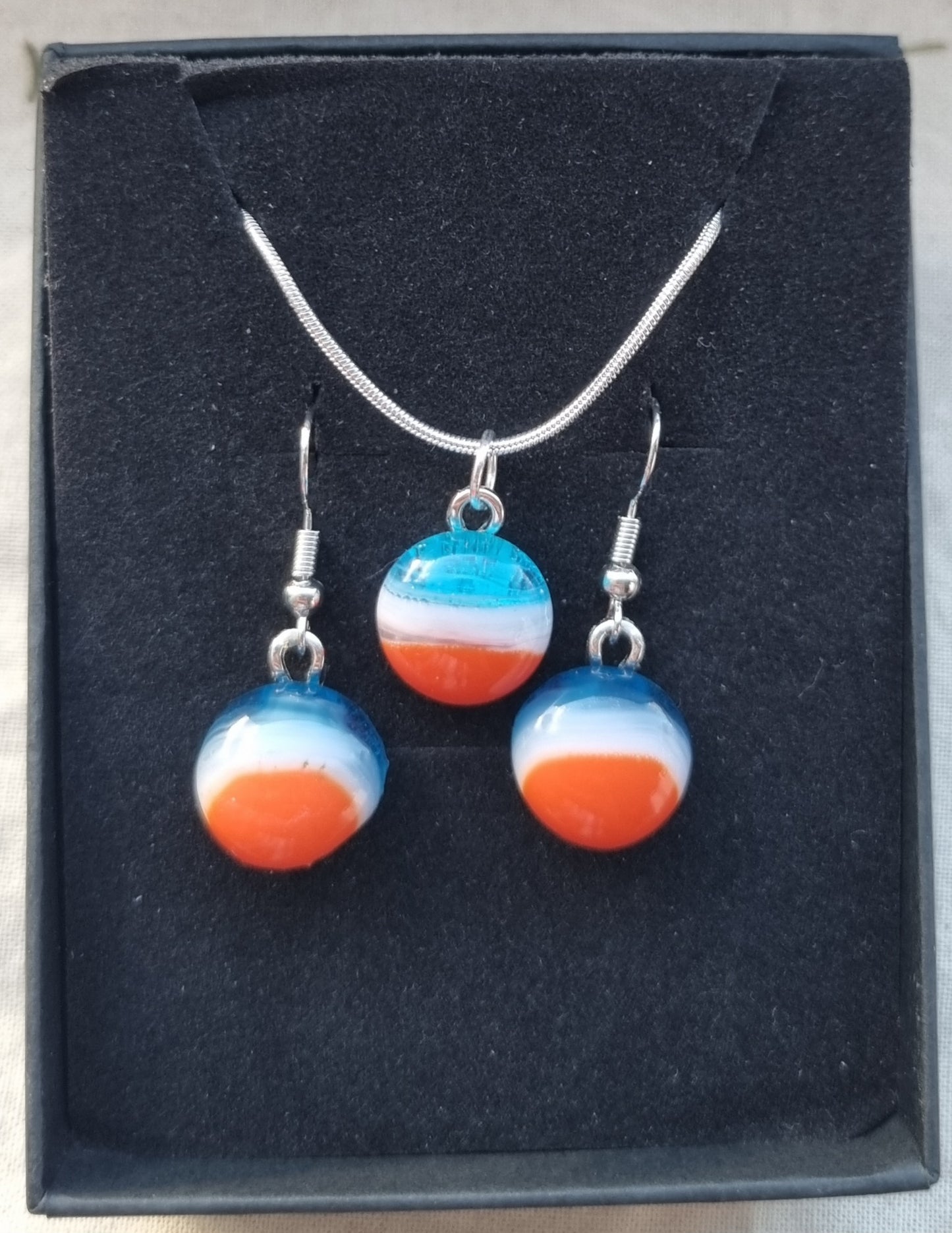 Blue, white and orange handmade glass pebble pendant.