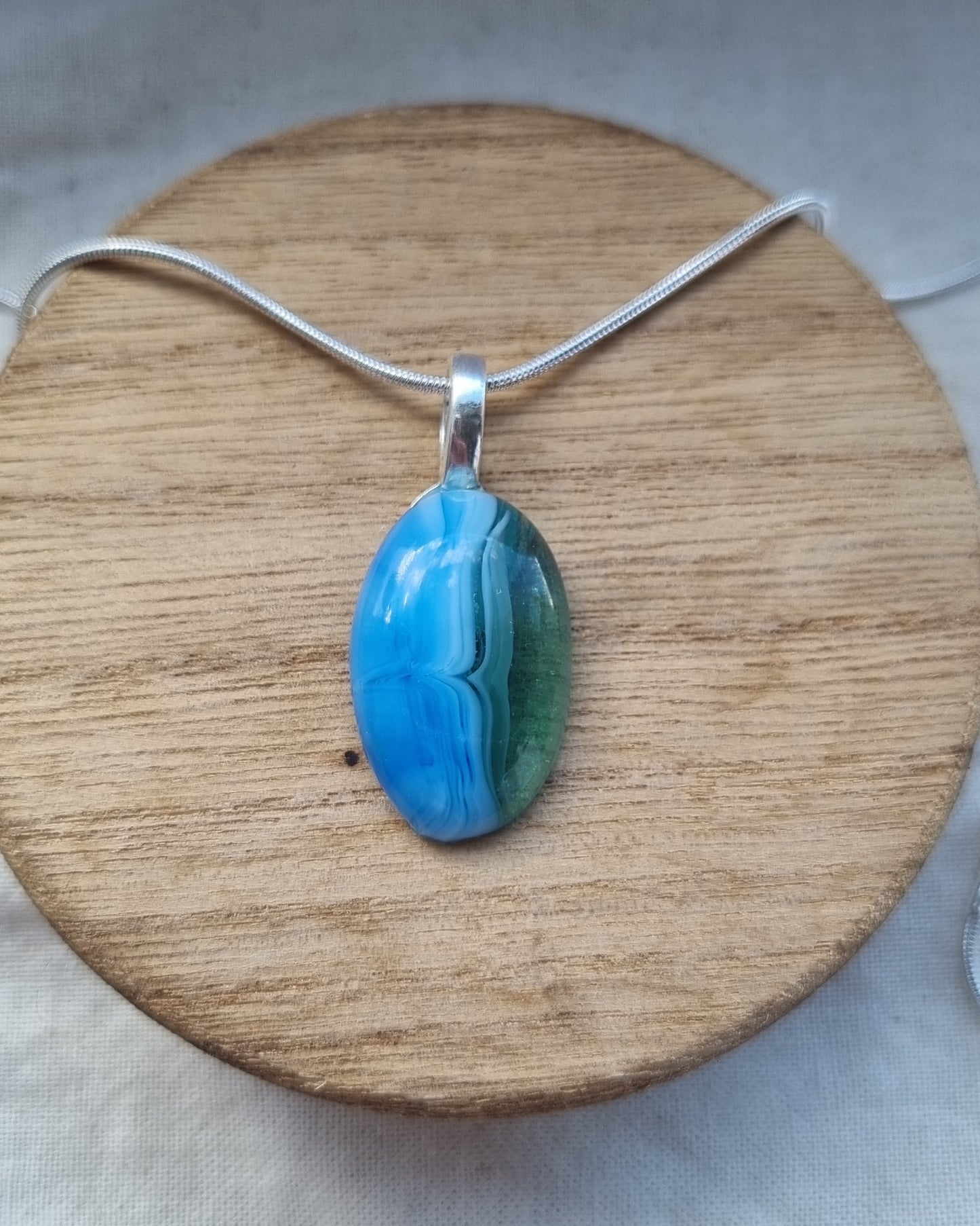 Ocean inspired, and green, handmade glass pebble pendant