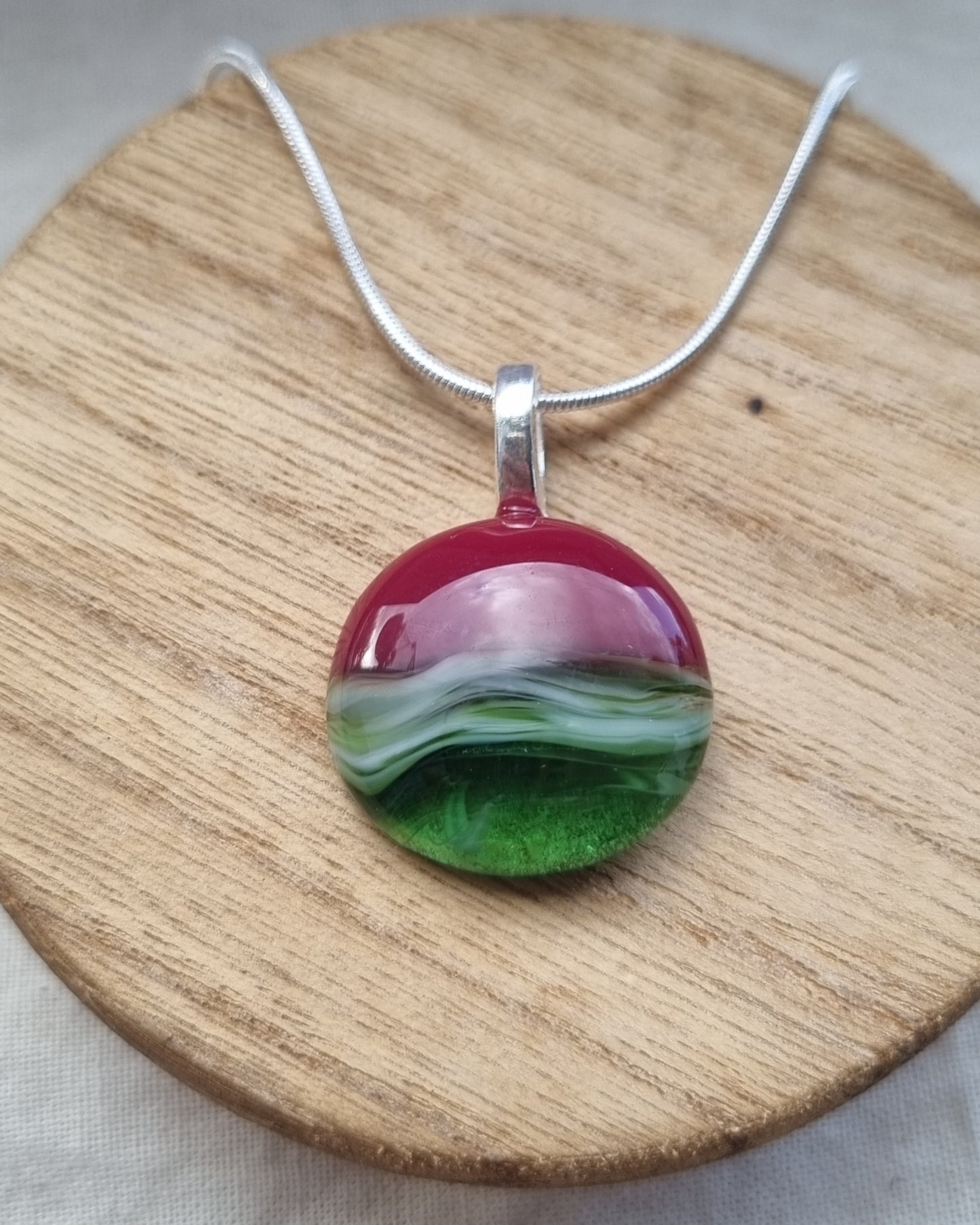 Shades of greens and red, handmade glass pebble pendant