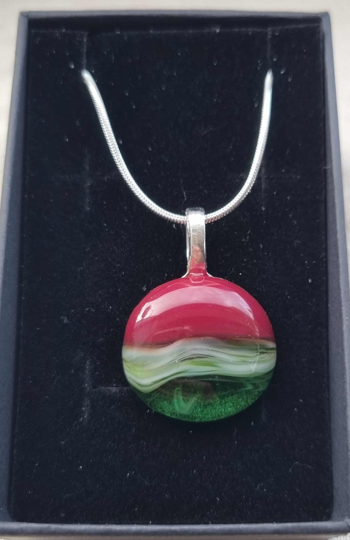 Shades of greens and red, handmade glass pebble pendant