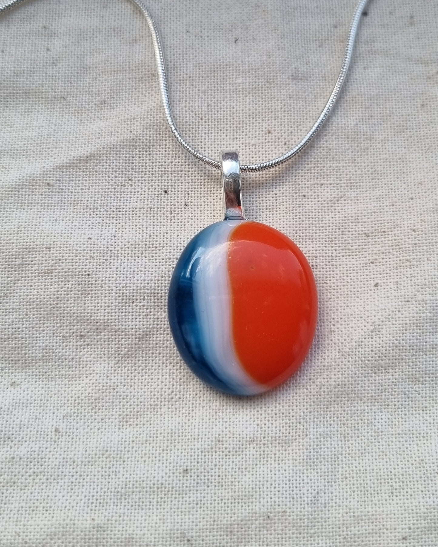 Blue, orange and white, handmade glass pebble pendant.