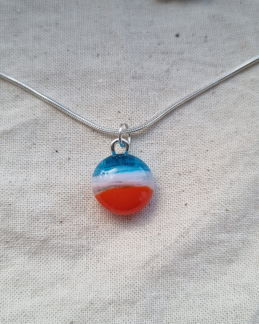 Blue, white and orange handmade glass pebble pendant.