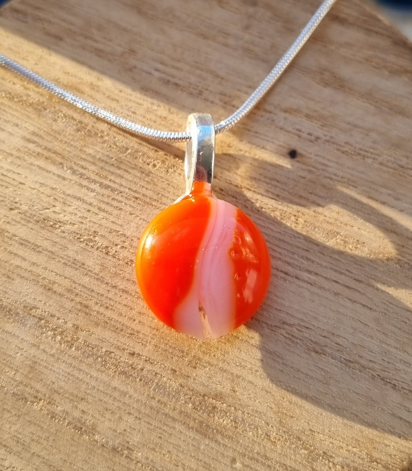 Orange and white, handmade glass pebble pendant