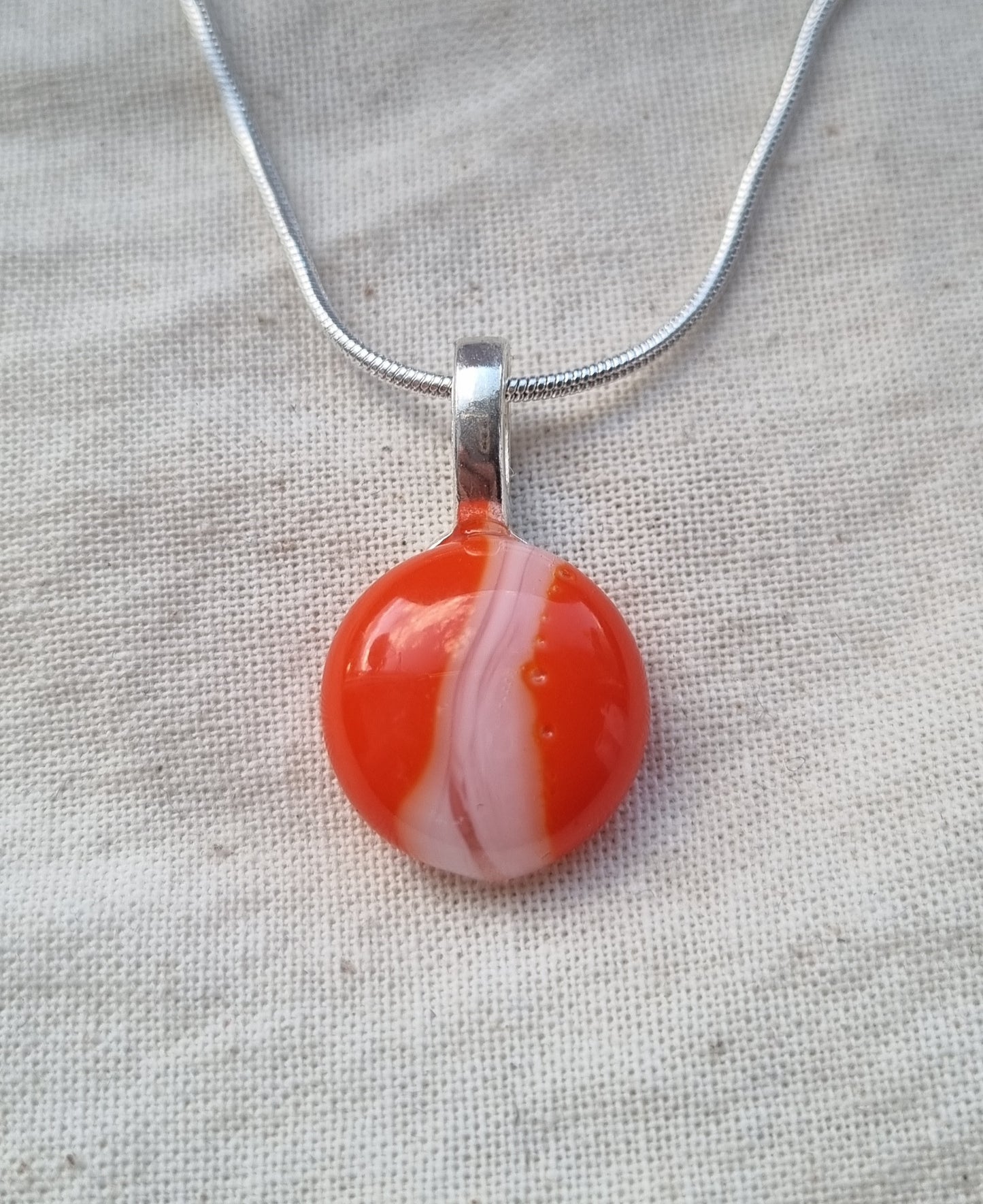 Orange and white, handmade glass pebble pendant