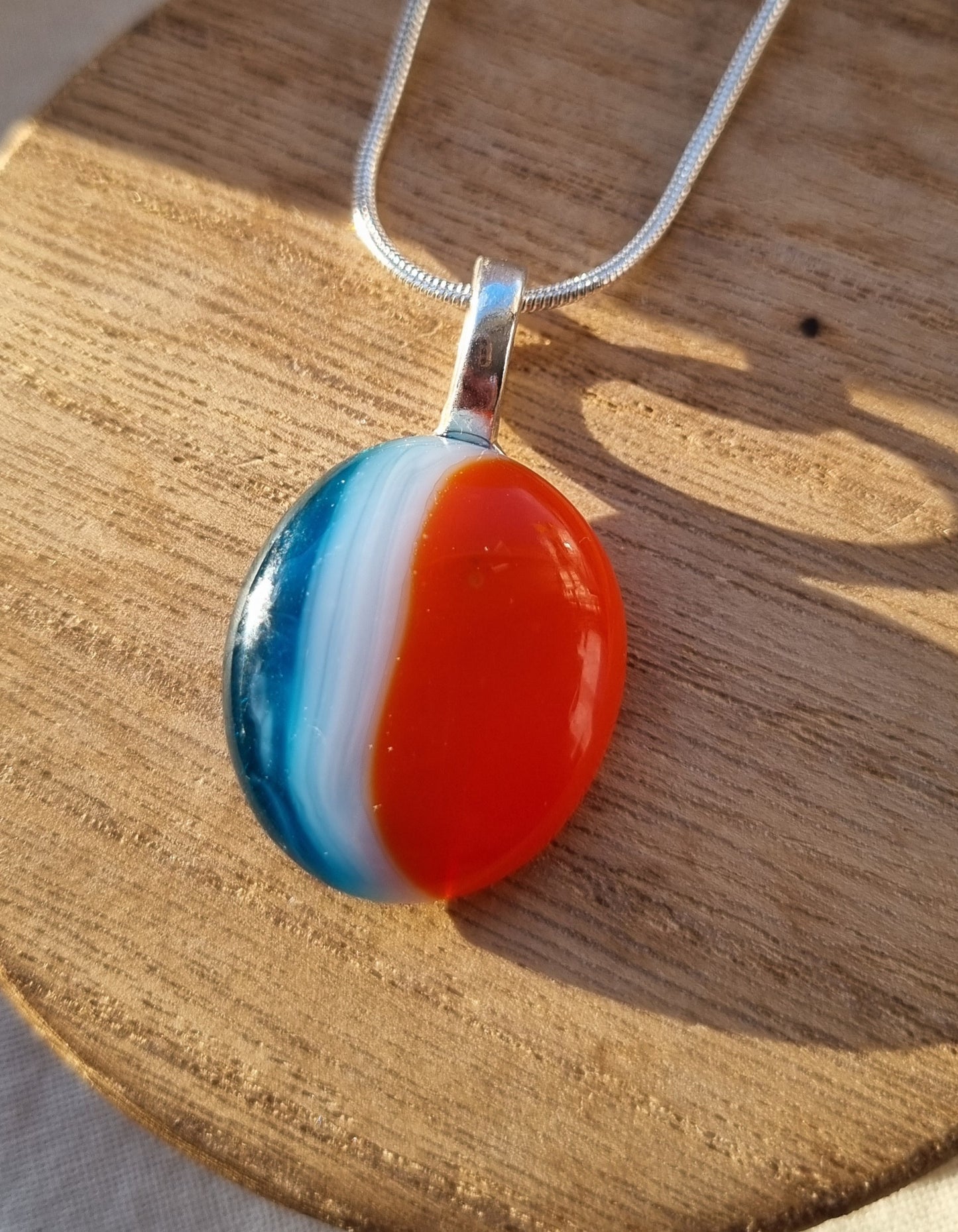 Blue, orange and white, handmade glass pebble pendant.